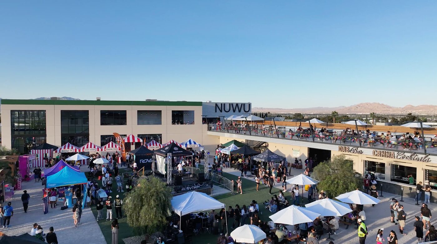 Aerial of the 420 State Fair at NuWu — packed courtyard, striped festival tents and the NUWU sign on Las Vegas Paiute land