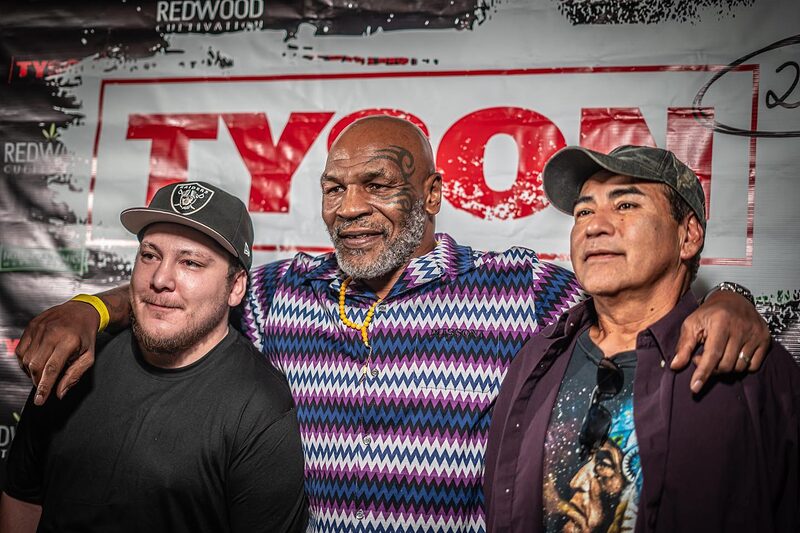 Mike Tyson posing with NuWu staff at a TYSON 2.0 event