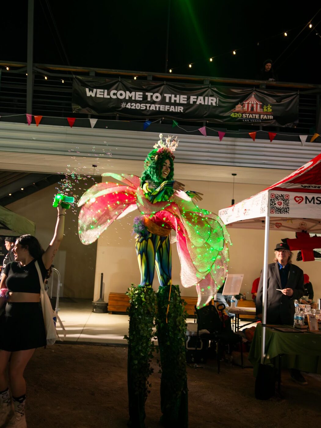 Stilt-walkers in leaf costumes welcome the crowd to the fair