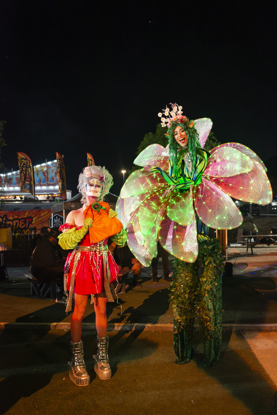 Costumed performers in LED butterfly and carnival looks